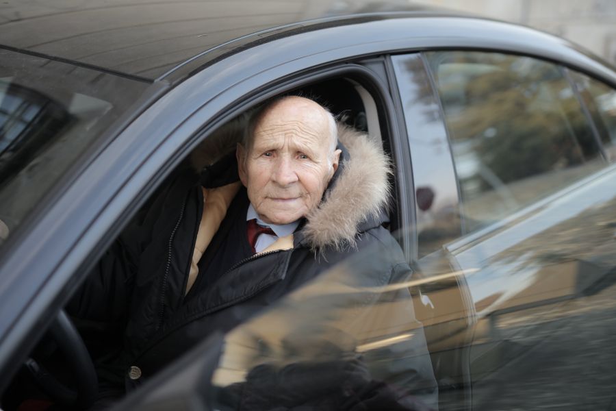 Conductor senior en automóvil invierno