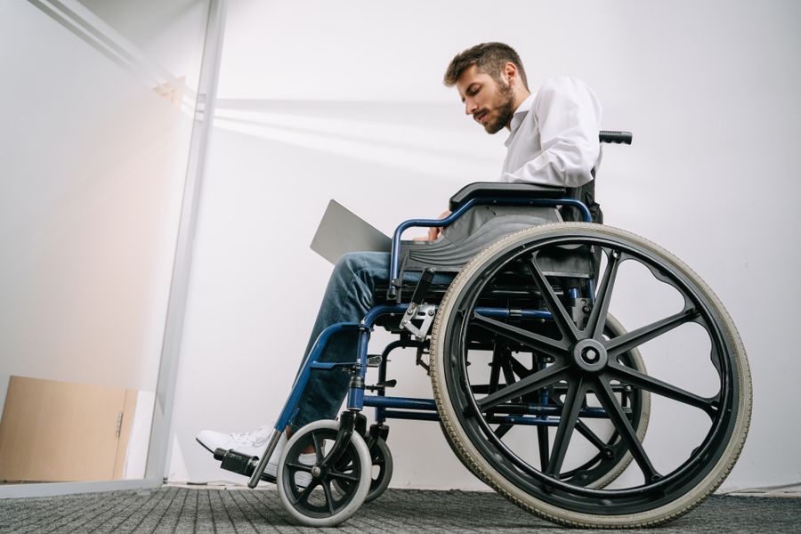Persona en silla de ruedas con portátil